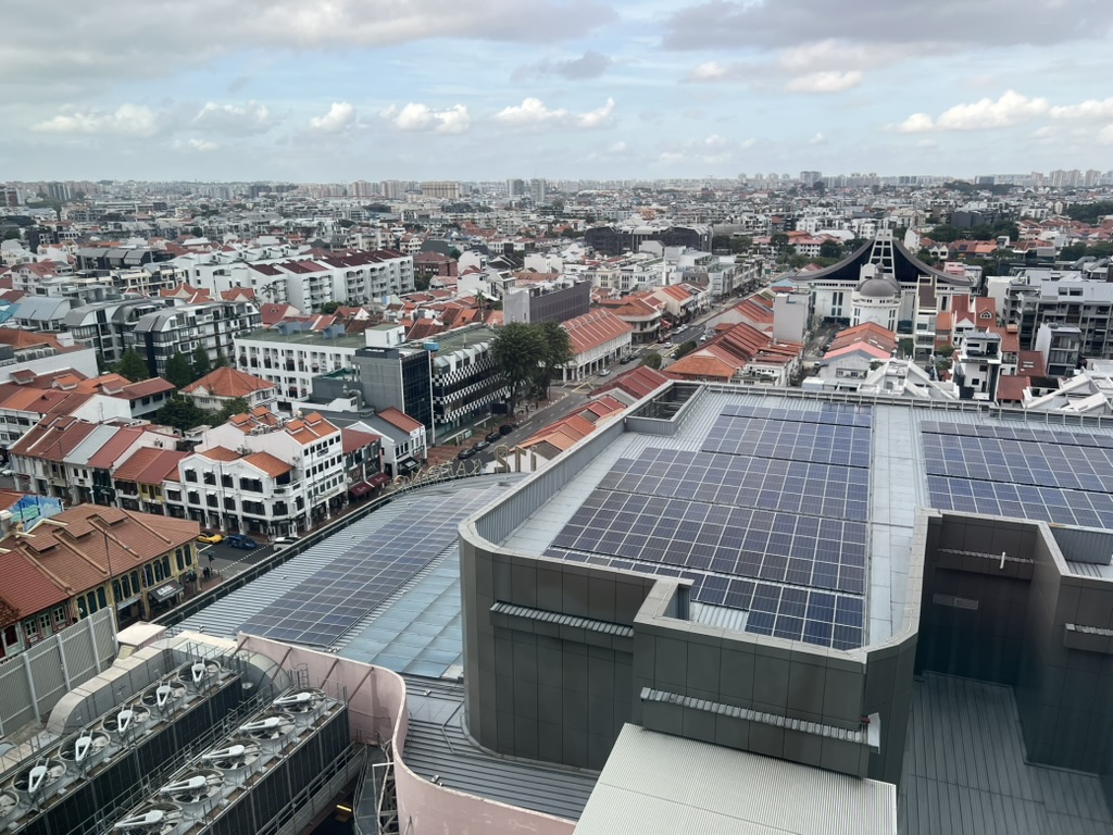 Singapore HDB blocks with some solar panels on rooftops, many roofs still empty.