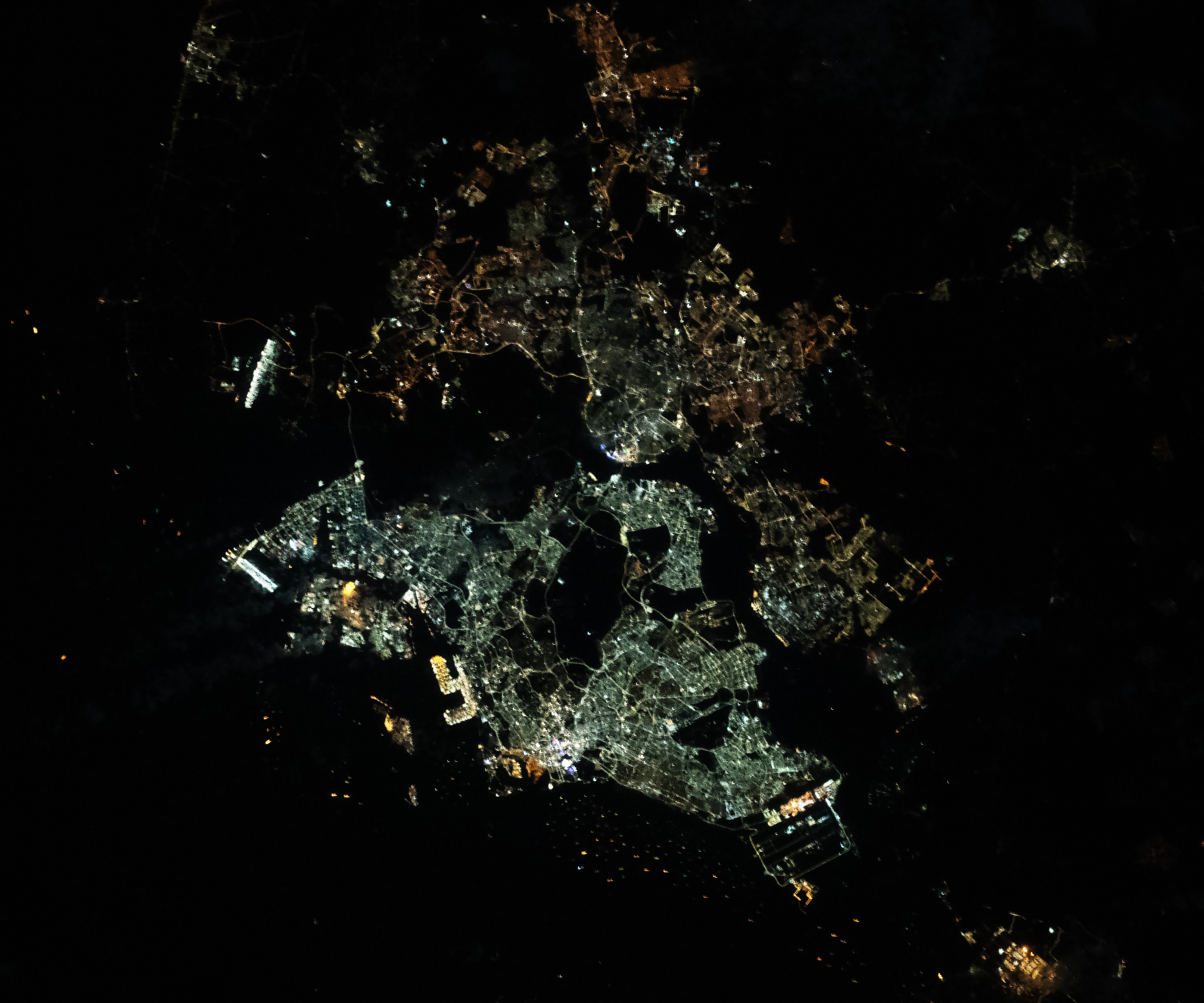 Nighttime photograph of Singapore and southern Malaysia taken from the International Space Station on January 26, 2024. City lights illuminate the coastlines while shipping lanes dot the Singapore Strait.