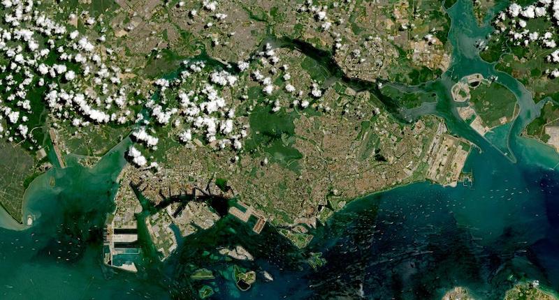 Satellite image of Singapore from Sentinel-2, May 10, 2021. The 733 square kilometre island is visible in its entirety, with Jurong Island's industrial complex to the southwest, shipping lanes filling the Singapore Strait, and Johor Bahru across the causeway to the north.